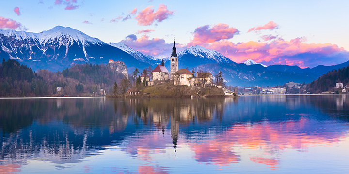 Sunset view of Julian Alps, Lake Bled with St. Marys Church of the Assumption on the small island. Bled, Slovenia, Europe.