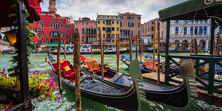 VENICE, ITALY - JUNE 26: Tourists travel on gondolas at canal on June 26, 2014 in Venice, Italy . Gondola trip is the most popular touristic activity in Venice.