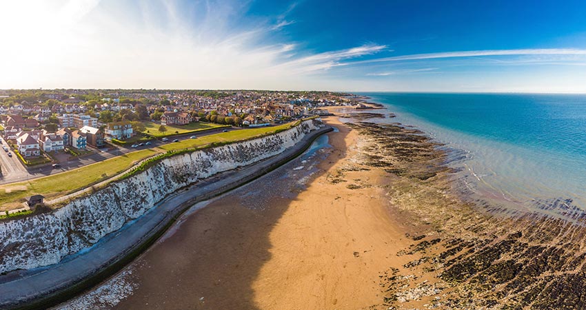 Aerial view of Margate coastline with sandy beach, chalk cliffs, and residential houses in Kent, England