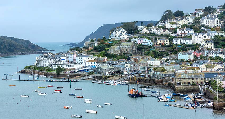 Salcombe harbour with colorful boats and hillside houses in South Devon, England