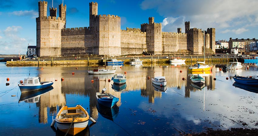 Caernarfon Castle on the water with boats in front