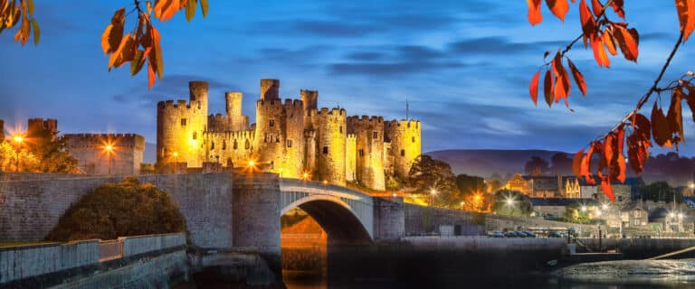 Evening shot of Conway castle in Wales lit up by lights