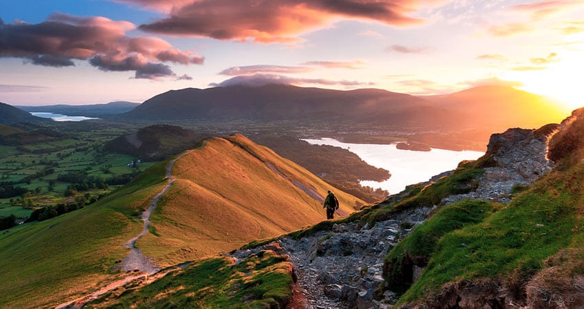 Man hiking the hills in lake district during a beautiful sunset
