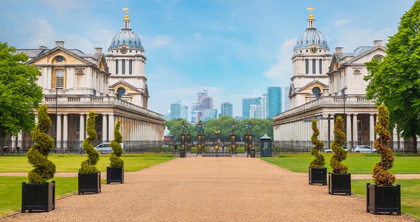 View of Maritime Greenwich gardens and buildings with London in the distance