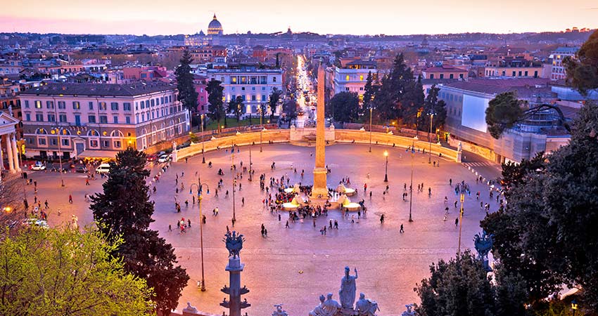 Aerial view of Piazza del Popolo during evening hours with tourists gathering at the obelisk