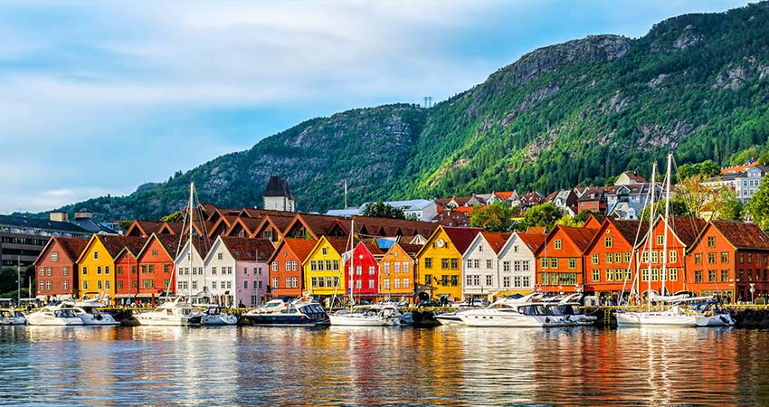 Daytime view of the colorful homes that sit along the water in Bryggen