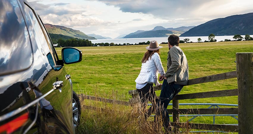 Couple enjoying the view of the highlands outside of their car