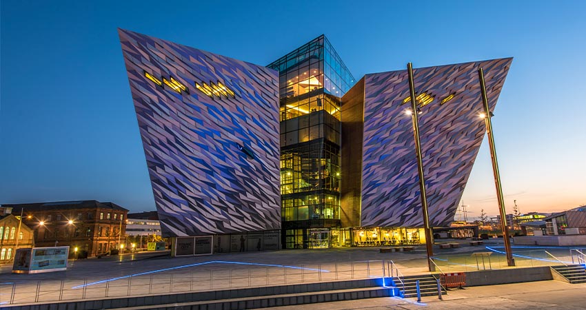 Titanic Visitor Center in Belfast lit up during evening hours